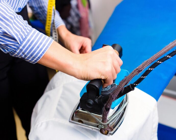 Laborer ironing a shirt at dry cleaner