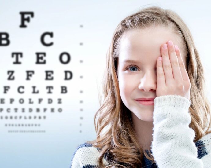Girl taking eye test, with on eye covered