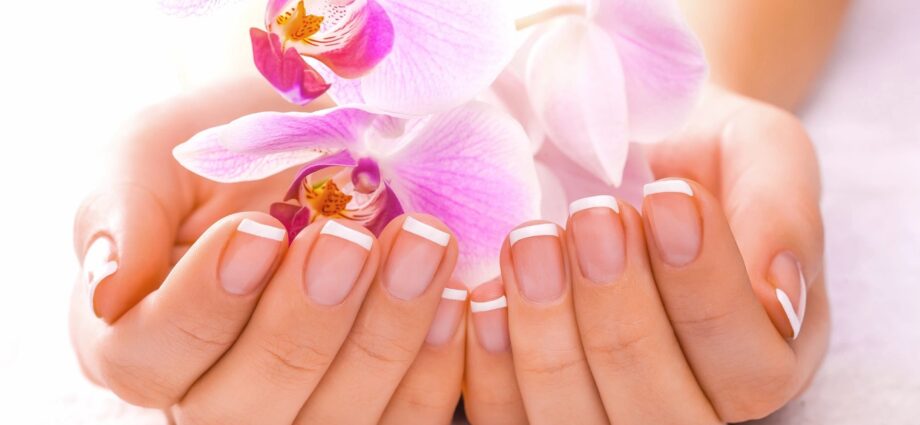 Hands holding a flower with perfectly manicured nails